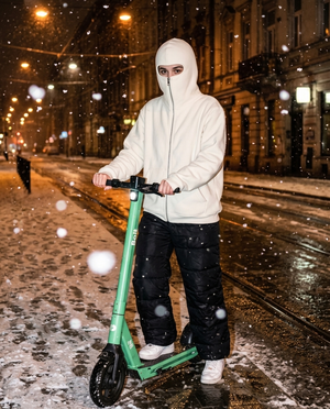 Biała bluza z kominiarką noszona na hulajnodze zimą