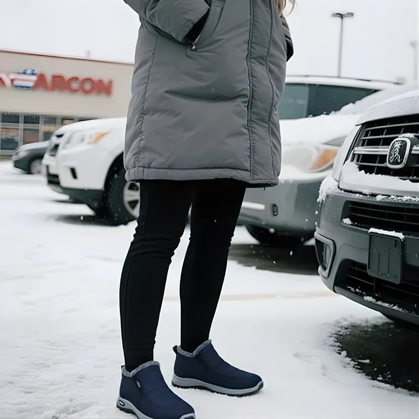 Kobieta w niebieskich botkach zimowych na zaśnieżonym parkingu
